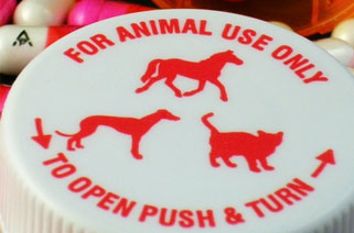 medicine bottle cap that says "For animal use only. To open push and turn" with pictures of a horse, cat and dog in red